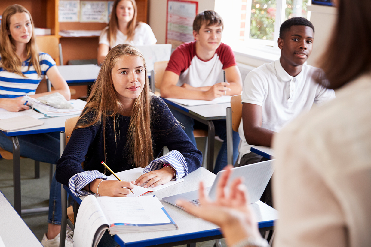 Estudiante comprometida en clase, demostrando motivación y actitud positiva en su formación.