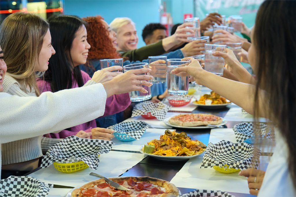Grupo de estudiantes internacionales comiendo juntos en un restaurante durante su experiencia en el extranjero.