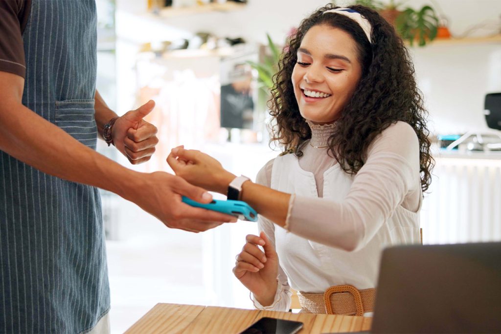 Estudiante utilizando un reloj inteligente para pagar mientras estudia en el extranjero.