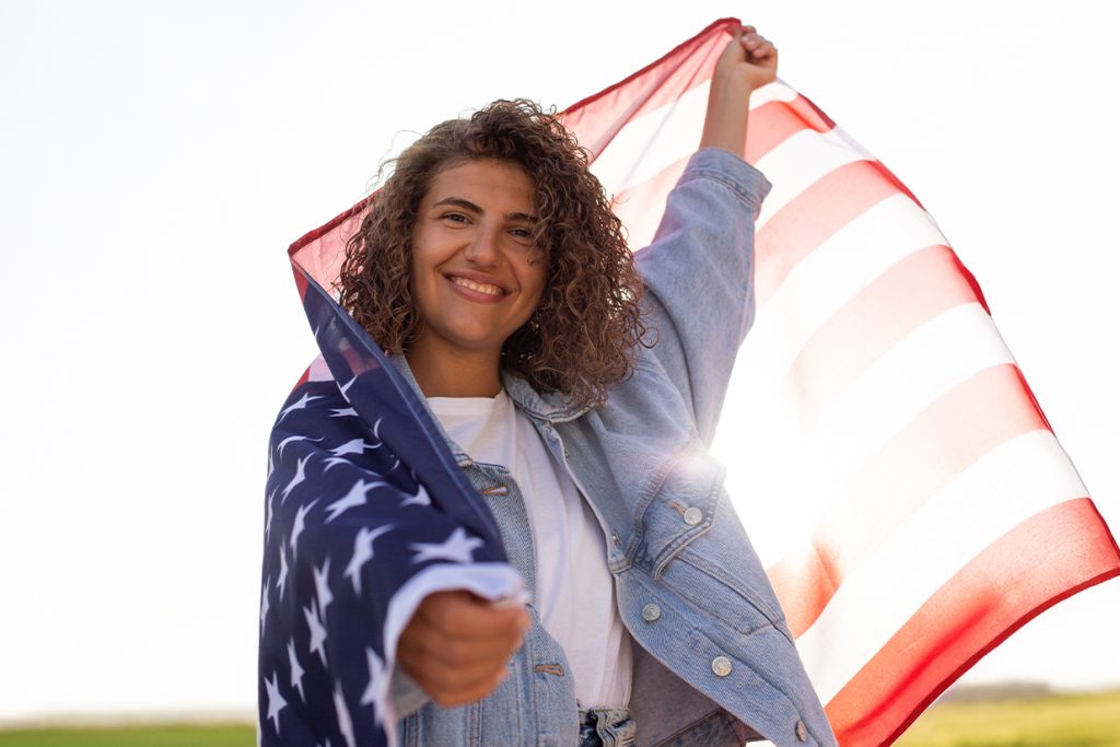 Estudiante internacional posando con la bandera de Estados Unidos durante su experiencia en el extranjero.