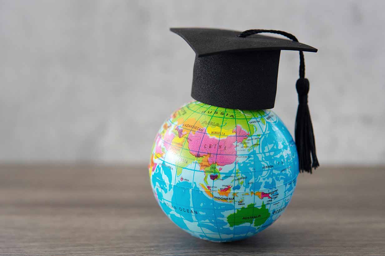 Estudiante comparando los mejores países para estudiar en el extranjero: Estados Unidos, Canadá, Reino Unido, Irlanda y Suiza.